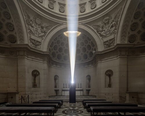 a beam of white light carves through paris’ historical chapel
